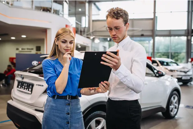 Car buyers reviewing financing paperwork with an advisor