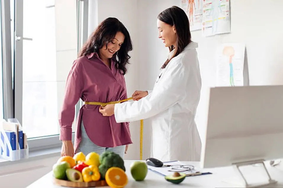 Doctor measuring patient waist