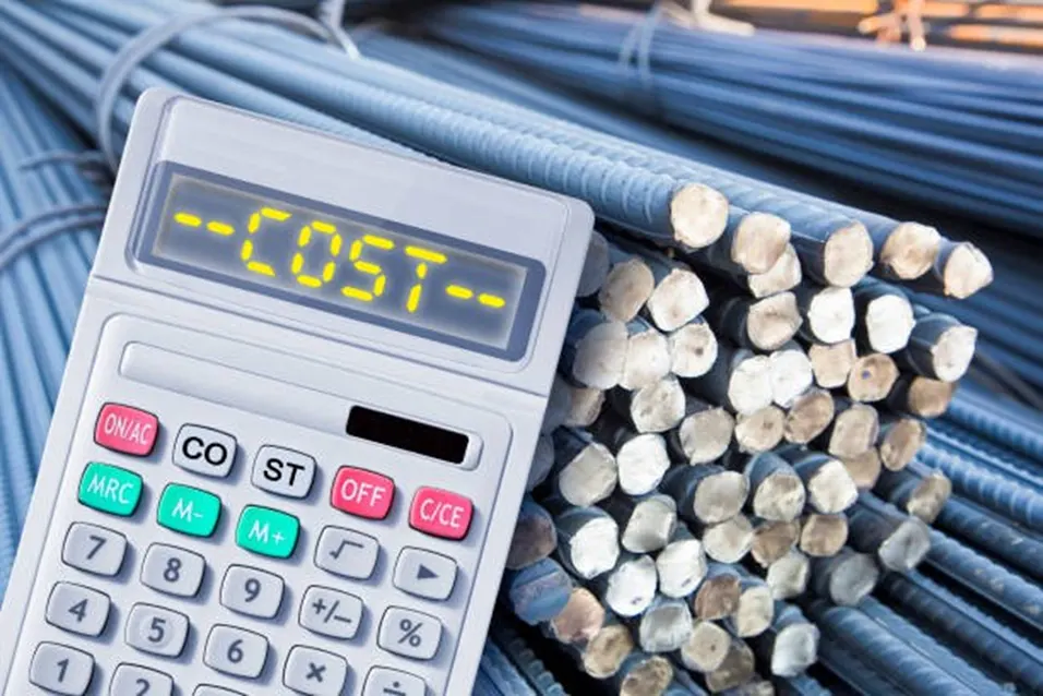 Calculator displaying COST resting against a bundle of steel reinforcement bars at a construction site