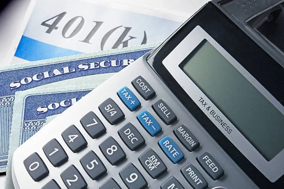 Tax and business calculator resting on Social Security cards and a 401k document