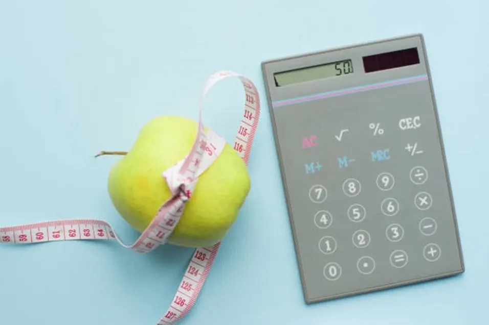 Apple with tape measure next to calculator