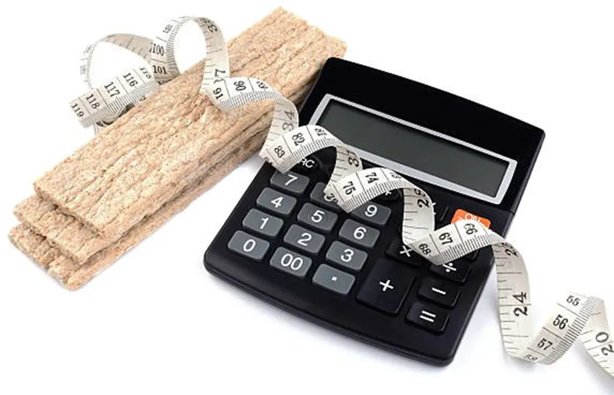 Black calculator with crispbread and tape measure