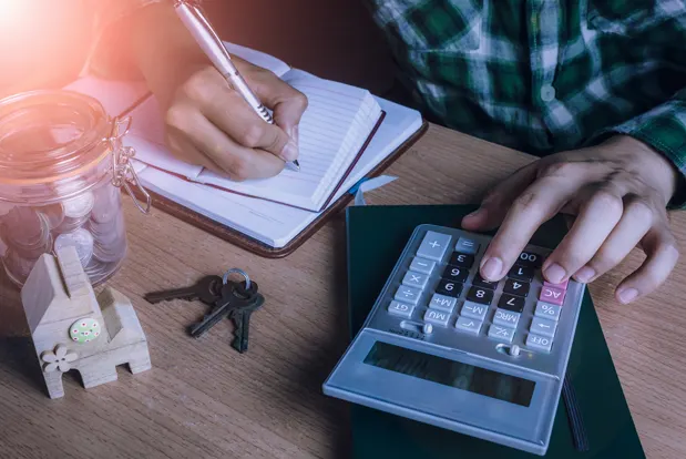 Person calculating mortgage payments with notepad