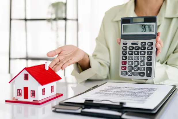 Agent presenting house model with mortgage calculator