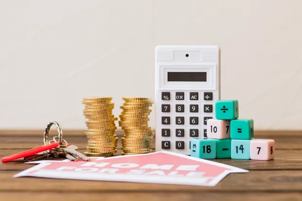 Mortgage home for sale with coins and calculator