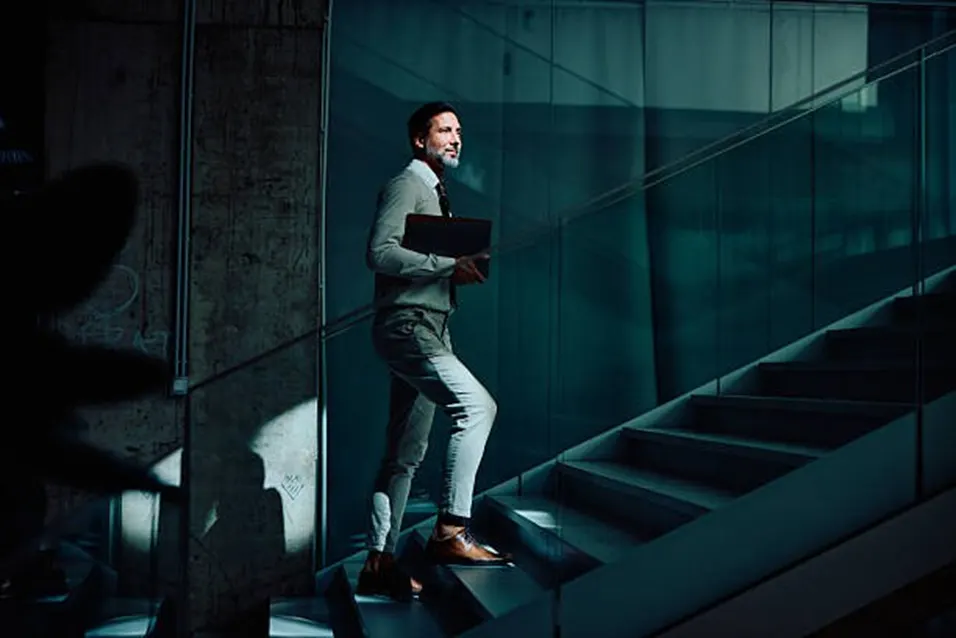 Businessman walking up stairs with purpose and confidence