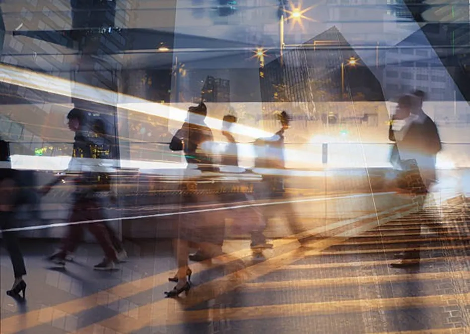 Busy commuters walking through a city at pace