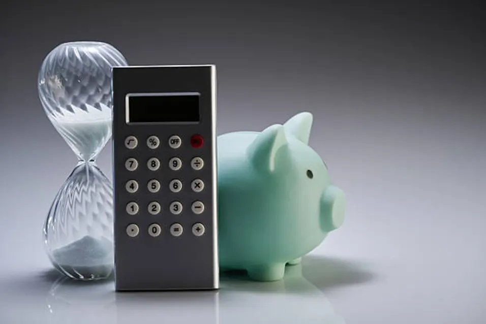 Calculator, hourglass and piggy bank representing pace and time planning