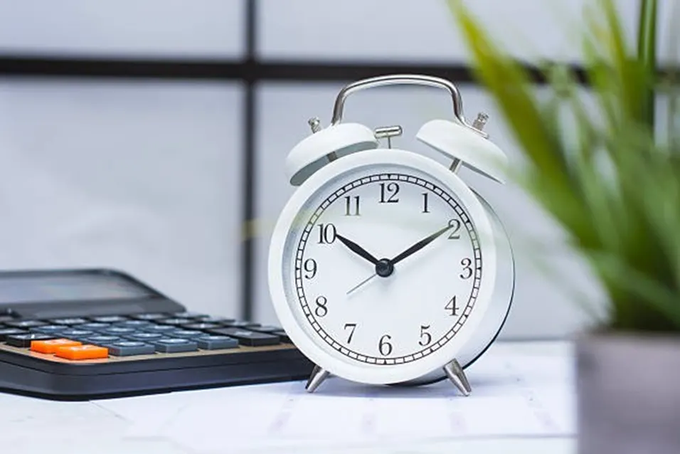 Alarm clock beside a calculator symbolising time and pace tracking