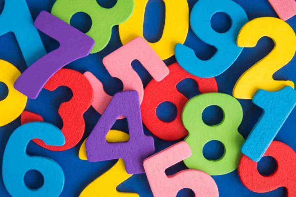 Scattered colourful wooden number tiles on a blue background