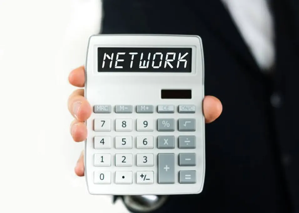 Person in a suit holding a calculator displaying the word NETWORK