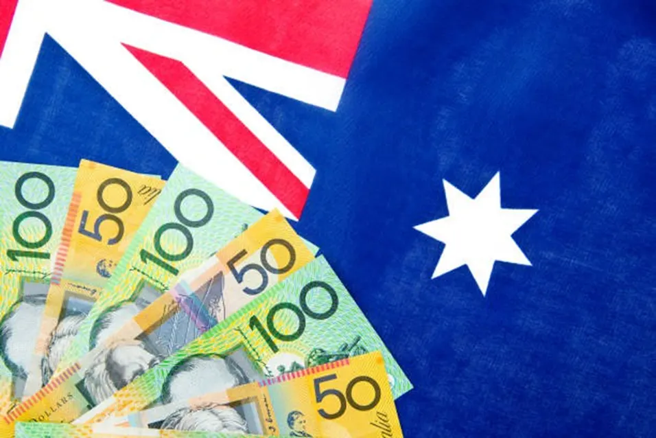 Australian 50 and 100 dollar banknotes fanned out over the Australian flag